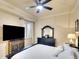 Bedroom with dark furniture set, white bedding, ceiling fan and serene ambiance at 8403 Grand Estuary Trl # 103, Bradenton, FL 34212