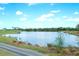 Picturesque pond surrounded by lush greenery and trees with blue sky and clouds at 8403 Grand Estuary Trl # 103, Bradenton, FL 34212