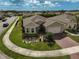 Aerial view of a single Gathering home showcasing its manicured lawn, brick driveway and landscaping at 9032 Excelsior Loop, Venice, FL 34293