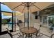 Screened in patio with outdoor seating, umbrella, and television at 9032 Excelsior Loop, Venice, FL 34293