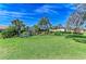 Spacious backyard featuring lush lawn, mature landscaping, and screened-in pool area, blending comfort and luxury at 10002 Cherry Hills Avenue Cir, Bradenton, FL 34202