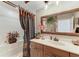 Bathroom vanity with decorative mirror, a soaking tub, and a decorative shower curtain at 10002 Cherry Hills Avenue Cir, Bradenton, FL 34202