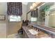 Elegant bathroom with granite countertop, decorative curtains, and large mirror creates a spa-like ambiance at 10002 Cherry Hills Avenue Cir, Bradenton, FL 34202