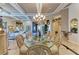 Elegant dining room with coffered ceiling, designer chandelier, and marble floors at 10002 Cherry Hills Avenue Cir, Bradenton, FL 34202