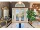 Grand foyer with decorative glass doors, marble floors, ornate mirror, and elegant foyer table at 10002 Cherry Hills Avenue Cir, Bradenton, FL 34202