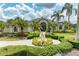 Stunning home exterior featuring lush landscaping, a circular driveway, and a beautiful water fountain at 10002 Cherry Hills Avenue Cir, Bradenton, FL 34202