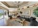 Spacious living room with hardwood floors, tray ceilings, and an oversized sectional sofa at 10002 Cherry Hills Avenue Cir, Bradenton, FL 34202