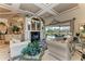 Inviting living room featuring a fireplace, stylish furniture, and sliding glass doors leading to a pool at 10002 Cherry Hills Avenue Cir, Bradenton, FL 34202