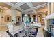 Grand living room with detailed ceiling, marble floors, elegant furnishings, and decorative columns at 10002 Cherry Hills Avenue Cir, Bradenton, FL 34202
