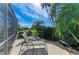 Outdoor patio featuring lounge chairs, mature tropical landscaping, and golf course views at 10002 Cherry Hills Avenue Cir, Bradenton, FL 34202