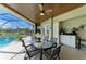 Inviting outdoor covered patio with ceiling fan, dining area, and built-in bar, perfect for entertaining near pool at 10002 Cherry Hills Avenue Cir, Bradenton, FL 34202