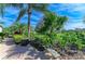 Green backyard with tropical landscaping and golf course views enhance the property's appeal at 10002 Cherry Hills Avenue Cir, Bradenton, FL 34202