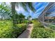 Outdoor brick pathway with tropical landscaping and views of the golf course at 10002 Cherry Hills Avenue Cir, Bradenton, FL 34202