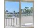 A close up of the balcony view looking at blue sky, mature landscaping and an American flag at 101 S Gulfstream Ave # 4J, Sarasota, FL 34236