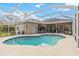 Aerial view of home's backyard featuring a screened-in pool, patio, and lush landscaping at 10306 Palmbrooke Ter, Bradenton, FL 34202