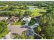 An aerial view of homes in a tranquil neighborhood bordering a scenic golf course and pond at 10306 Palmbrooke Ter, Bradenton, FL 34202