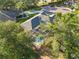 Aerial view of a property with a screened-in pool enclosure, showcasing the surrounding lush trees at 10306 Palmbrooke Ter, Bradenton, FL 34202