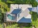 Aerial view showing house roof, pool, screened enclosure, landscaping, and surrounding greenery at 10306 Palmbrooke Ter, Bradenton, FL 34202