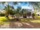 Lush backyard featuring a variety of palm trees and an enclosed patio with a pool at 10306 Palmbrooke Ter, Bradenton, FL 34202