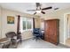 This bedroom has a ceiling fan, a window view and a comfortable sitting area at 10306 Palmbrooke Ter, Bradenton, FL 34202