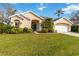 Charming home exterior with well-manicured lawn, landscaping, and bright blue door at 10306 Palmbrooke Ter, Bradenton, FL 34202