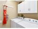 Practical laundry room with a washer, dryer, and overhead cabinets for storage at 10306 Palmbrooke Ter, Bradenton, FL 34202