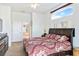 Comfortable main bedroom featuring a doorway to the ensuite, vaulted ceiling, large window, and ceiling fan at 10306 Palmbrooke Ter, Bradenton, FL 34202