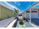 Charming backyard featuring a white bench, lush greenery, and a lovely trellis at 10315 Cortez W Rd # 17F, Bradenton, FL 34210
