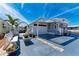 Quaint home featuring an attached carport, beautiful flowers, and white picket accents at 10315 Cortez W Rd # 17F, Bradenton, FL 34210