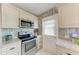 Kitchen featuring stainless steel appliances, white cabinets, and convenient back door access at 10315 Cortez W Rd # 17F, Bradenton, FL 34210
