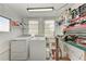 Clean laundry room featuring a washer, dryer, utility sink, and ample storage shelves at 10315 Cortez W Rd # 17F, Bradenton, FL 34210