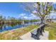 Scenic waterfront view with a calm lake, fountain, lush landscaping, benches, and a charming gazebo at 10315 Cortez W Rd # 17F, Bradenton, FL 34210