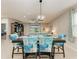 Bright dining area featuring a modern light fixture, a dark wood table, and stylish blue upholstered chairs at 11015 48Th E St, Parrish, FL 34219