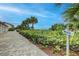 Charming brick-paved path lined with lush greenery and palm trees, leading directly to the beautiful beach at 1141 W Peppertree Dr # 1141, Sarasota, FL 34242