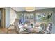 Bright dining area with a glass table, wicker chairs, and scenic views of a tranquil pond at 1141 W Peppertree Dr # 1141, Sarasota, FL 34242