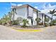 Beautiful exterior corner view featuring tropical landscaping, brick pavers, and ample parking at 1141 W Peppertree Dr # 1141, Sarasota, FL 34242