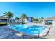 Sparkling swimming pool surrounded by comfortable lounge chairs, palm trees and a white fence, perfect for relaxation at 1141 W Peppertree Dr # 1141, Sarasota, FL 34242