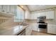 Well-lit kitchen with modern stainless steel appliances, white cabinets, and neutral countertops at 1310 Grand Blvd # 202, Sarasota, FL 34232