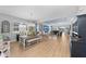 Open dining area with a wooden table, bench seating, modern lighting, and views of the living area at 14238 59Th E Cir, Bradenton, FL 34211