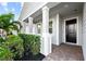Stylish front entrance featuring a black door, gray siding, and beautiful landscaping at 14238 59Th E Cir, Bradenton, FL 34211