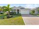 Charming single-story home with a well-manicured lawn, brick driveway, and attached two-car garage at 14238 59Th E Cir, Bradenton, FL 34211