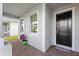 Charming front porch with gray siding, brick pavers, and a welcoming black front door at 14238 59Th E Cir, Bradenton, FL 34211