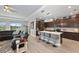 Modern kitchen island with seating, view of the adjacent living room, and stainless appliances at 14238 59Th E Cir, Bradenton, FL 34211