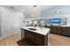 Modern kitchen island with a stainless steel sink, brown cabinets, and an open concept layout at 14238 59Th E Cir, Bradenton, FL 34211