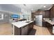Open kitchen with stainless steel appliances, a large island, and an open living area at 14238 59Th E Cir, Bradenton, FL 34211