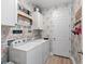 Bright laundry room with washer, dryer, and storage, showcasing modern wallpaper for a functional yet stylish space at 14238 59Th E Cir, Bradenton, FL 34211
