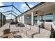 Spacious screened-in patio with lake view, featuring a seating area, a hot tub, ceiling fan, and TV for outdoor entertainment at 14238 59Th E Cir, Bradenton, FL 34211