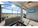 Inviting screened-in patio with views of the lake, featuring comfortable seating, a TV, and a ceiling fan at 14238 59Th E Cir, Bradenton, FL 34211