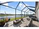 Lakeside screened patio with seating area, fire pit, hot tub, and scenic views, perfect for outdoor relaxation at 14238 59Th E Cir, Bradenton, FL 34211