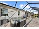 Enclosed patio featuring hot tub, outdoor seating, and pavers for a cozy and relaxing outdoor experience at 14238 59Th E Cir, Bradenton, FL 34211